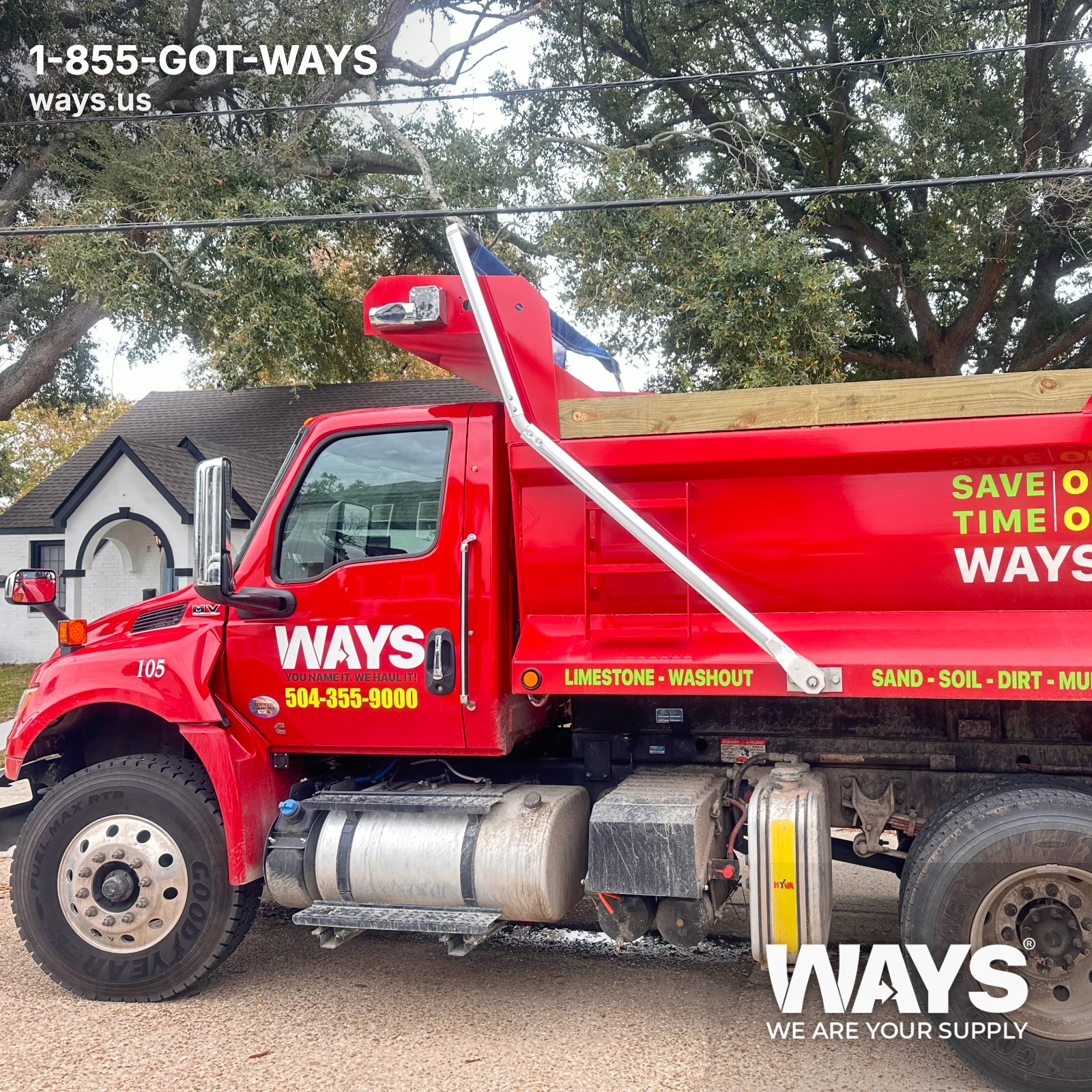 Red WAYS Materials dump truck parked on a New Orleans Metro residential street ready for delivery