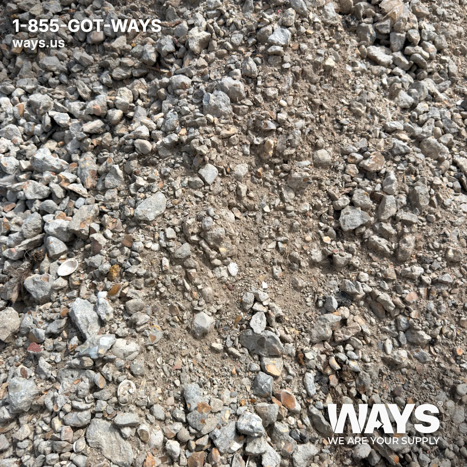 Close-up of crushed concrete pieces held in a gloved hand showing angular texture and gray color